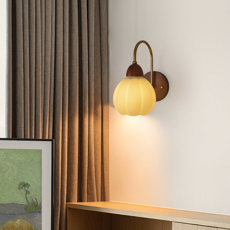 Walnut wood single-head mid-century wall sconce shown top-down angle with walnut finish mounted on dining room wall