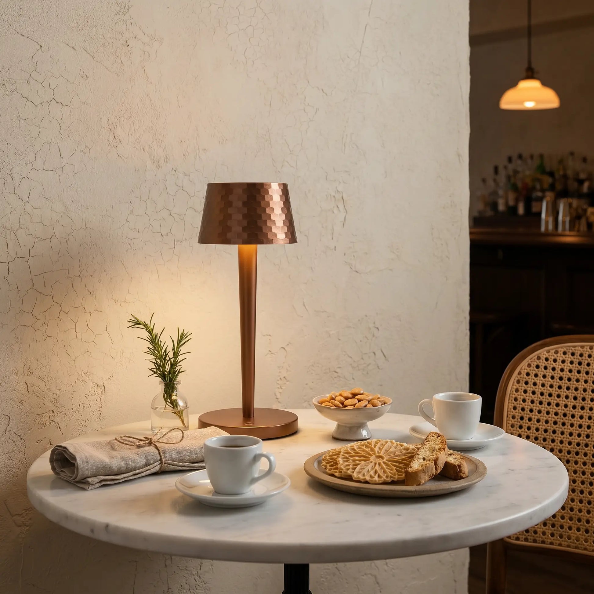 Aluminum touch dimmable USB rechargeable LED bedside lamp eye-level wide view in brushed aluminum lit on marble bistro table in trattoria